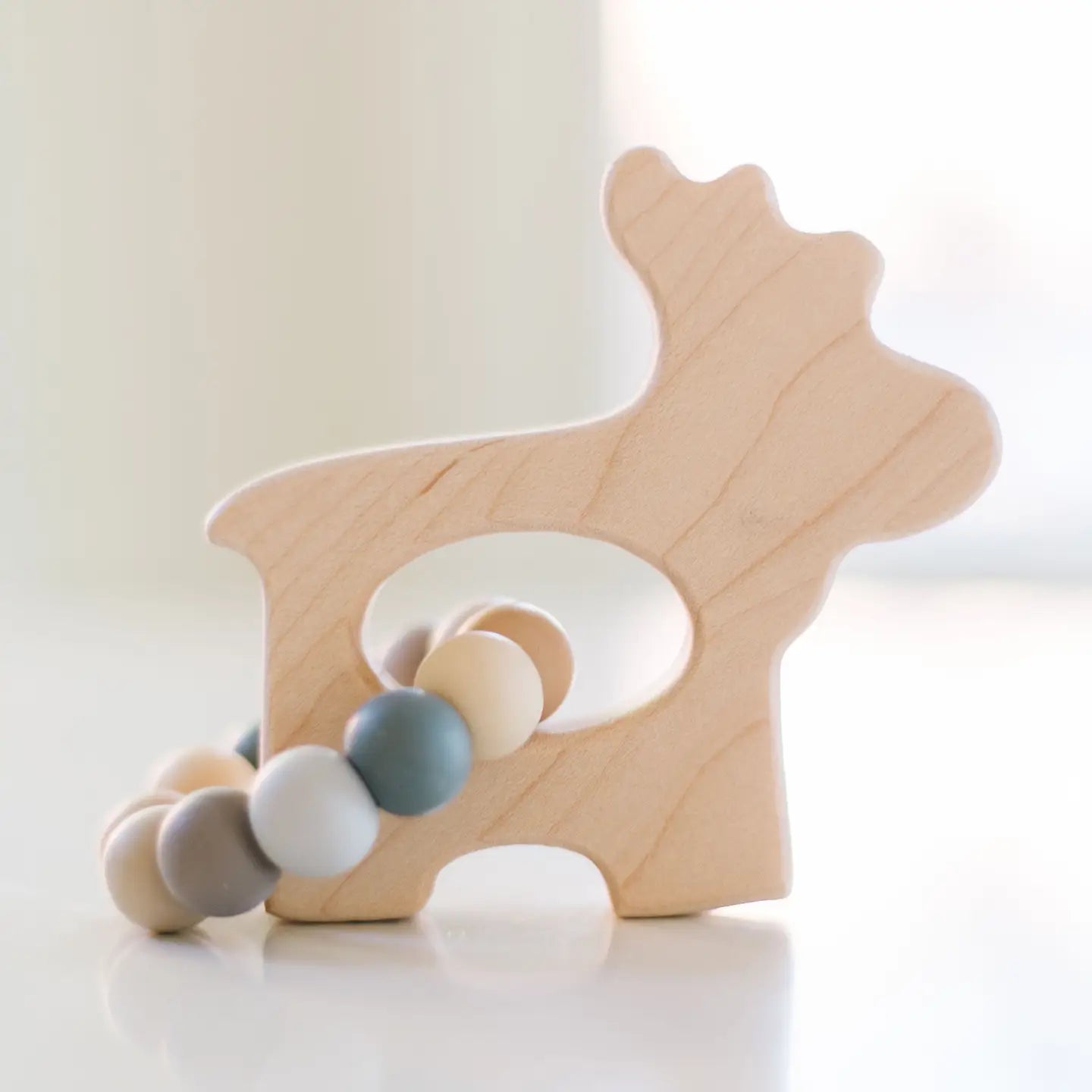 moose grasping wooden baby toy with teething beads